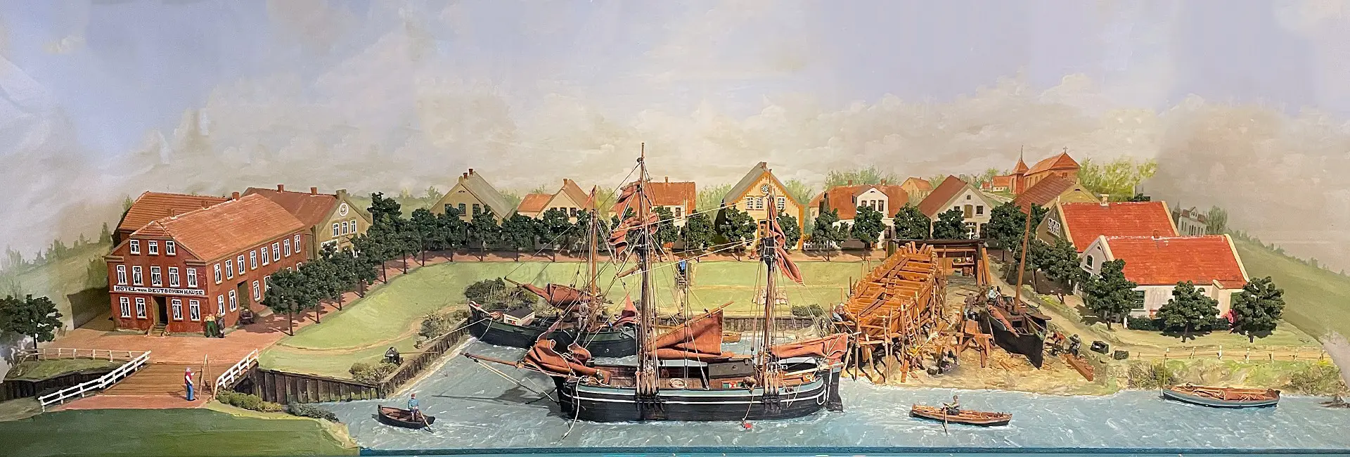 Modell des historischen Sielhafens in Carolinensiel mit zwei alten Schiffen, kleinen Booten, Häusern und Menschen